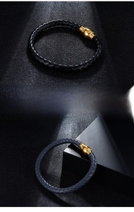 Detail of woven leather bracelets in black and blue with fine steel gold-tone clasps