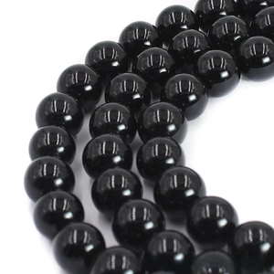 Macro shot of polished black agate round beads with glossy surface for DIY jewelry
