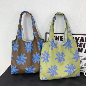 Detail view of brown and olive green canvas tote bags with blue floral print