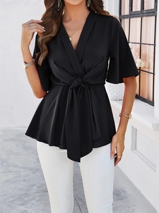 Détail du haut élégant noir à col en V avec ceinture à nouer et manches mi-longues