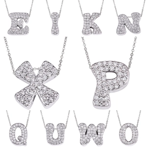 Macro view of silver bubble initial pendants encrusted with cubic zirconia stones