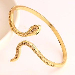 Detailed view of snake head bracelet with white zircons and green gemstone eyes