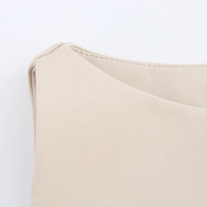 Detailed macro shot of beige fabric texture and premium stitching on the dress edge