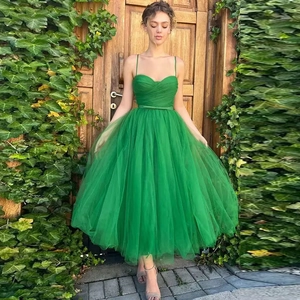 Detail of emerald green mesh prom dress showing thin straps and sweetheart neckline