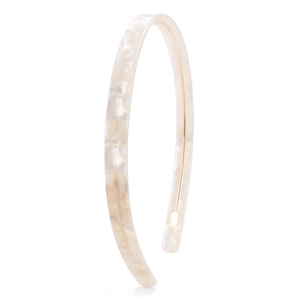Detailed view of cream marble acetate headband with elegant golden metal accent piece