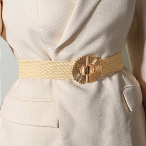 Detail view of a beige elastic woven belt featuring a vintage gold round alloy buckle