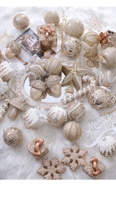 Detailed flat lay of champagne gold Christmas ornaments on a white faux fur background