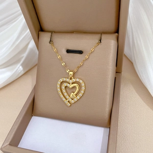 Elegant gold titanium triple heart necklace with sparkling crystals in a jewelry box