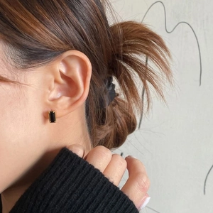 Minimalist rectangular black zircon earrings in gold finish worn by a model