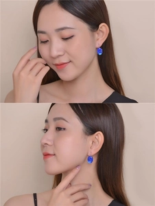 Close-up of elegant blue oval zircon earrings on a model with silver metal hooks