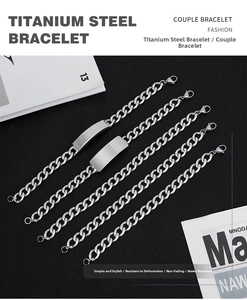 Close-up of polished silver titanium steel Cuban chain bracelets on a black background
