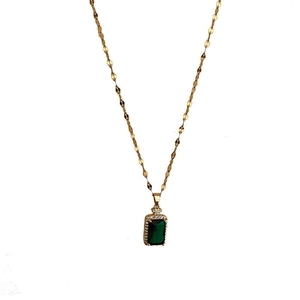 Detail of gold chain necklace with rectangular emerald green gemstone and crystal accents