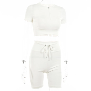 Detail of white ribbed two-piece set featuring front zipper and drawstring waist
