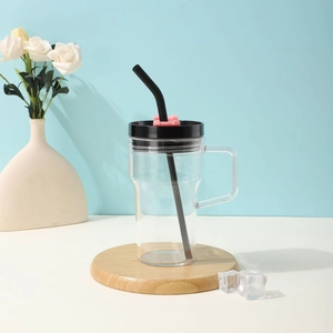 Detail of a large plastic cup with handle, black lid and straw on a modern blue background