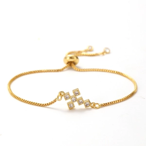 Detail of adjustable gold cross bracelet with shimmering zircon stones and box chain link