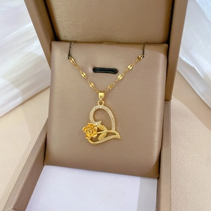 Luxurious gold heart pendant necklace with rose and crystals in a beige jewelry box