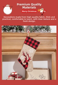 Close-up of burlap Christmas stocking with red plaid reindeer and white snowflake embroidery