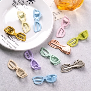 Sunglasses shaped hair clips in various macaron colors on a decorative ceramic plate