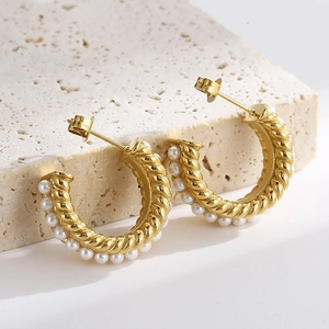 French vintage golden C-shape hoop earrings with white pearls on a minimalist stone