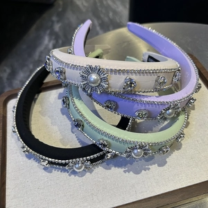 Detail of handmade rhinestone and pearl headbands in purple, beige, and mint colors