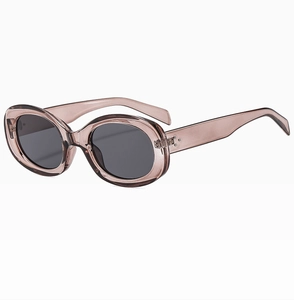 Detailed close-up of retro oval sunglasses with translucent tea-grey frame and dark grey lenses