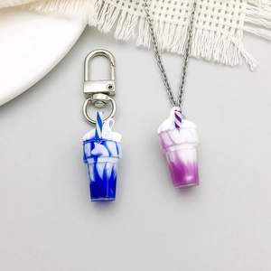 Detail view of resin drink cup pendants in blue and purple for DIY jewelry making