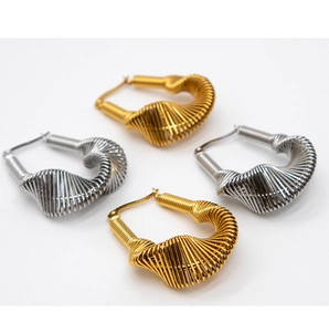 Macro shot of gold and silver spiral twist hoop earrings with elegant metal texture