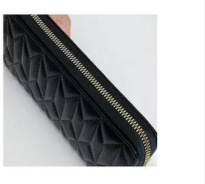 Detail of black quilted faux leather wallet with premium golden metal zipper and stitching