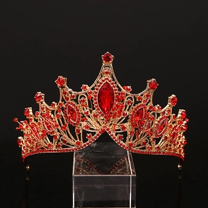 Vintage golden crown for women featuring elegant red crystals on a dark background