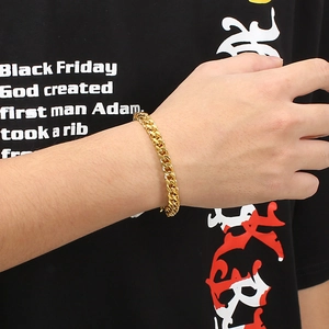 Detail of gold-plated square keel link bracelet worn on wrist for a street style look