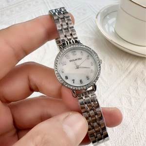 Silver crystal-bezel metal watch with mother of pearl dial on a woman's wrist