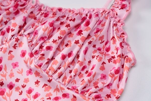 Detailed close-up of pink floral bikini top with ruffled straps and pleated chest design