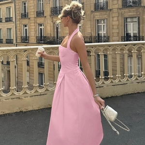 Dettaglio dell'abito rosa con scollo all'americana, vita alta e gonna plissettata
