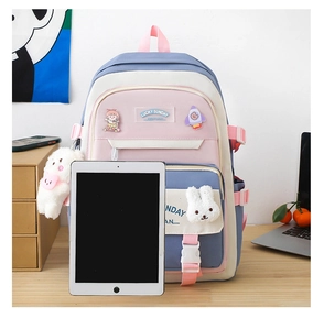 Detailed view of purple nylon backpack with cute badges and plush charms on wooden desk