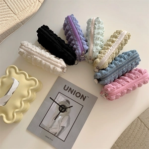Macro shot of bubble textured stationery pouches in various pastel colors with metal zippers