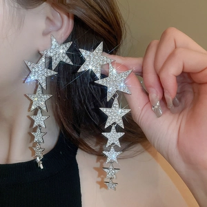 Close-up of sparkling star tassel earrings with silver rhinestones on a female model
