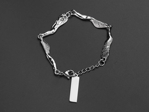 Macro shot of silver irregular textured metal link bracelet with blank rectangular tag