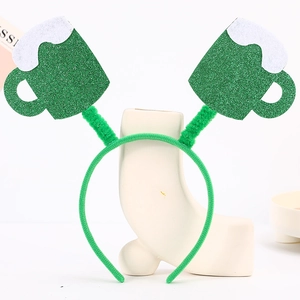 Close-up of glittery green beer mugs on a Saint Patrick's Day headband on white stand