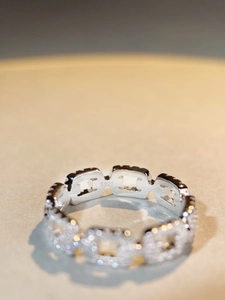 Macro shot of S925 sterling silver stamp on a chain link ring with pavé diamonds