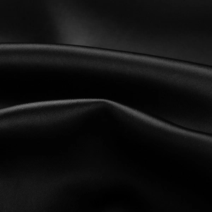 Close-up of high-shine black satin fabric showing premium smooth texture and elegant drapes