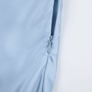 Gros plan détaillé sur la fermeture éclair invisible d'une robe longue en satin bleu