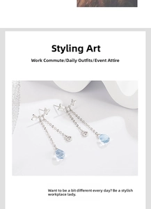 Close-up of silver butterfly tassel earrings with light blue teardrop gemstones