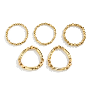 Set of 5 minimalist gold beaded bracelets with heart pendants for a layered jewelry look
