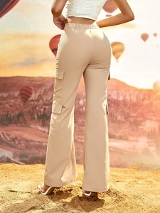 Women's khaki cargo flare pants with multi-pocket design shown in outdoor desert setting