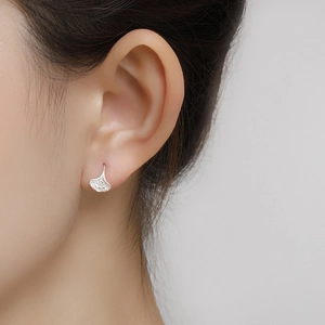 Detail of S999 sterling silver ginkgo leaf earring with fine texture on woman's ear