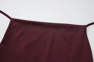 Détail du tissu tricoté bordeaux avec fine bretelle et finition texturée lisse