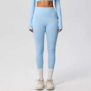 Detail view of high-waist light blue yoga pants with side pockets and smooth brushed fabric