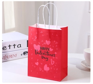 Close-up of a red Valentine's Day gift bag with pink hearts and Happy Valentine's Day text