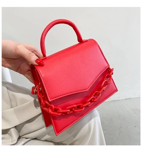 Detail of red fashion handbag with thick acrylic chain and elegant flip cover