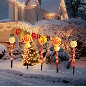 Solar outdoor Christmas garden lights with glowing snowman and lollipop stakes in snow